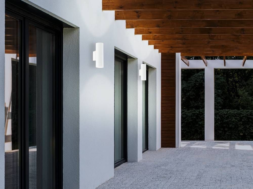 Mise en ambiance extérieure sur une façade blanche sous une pergola en bois