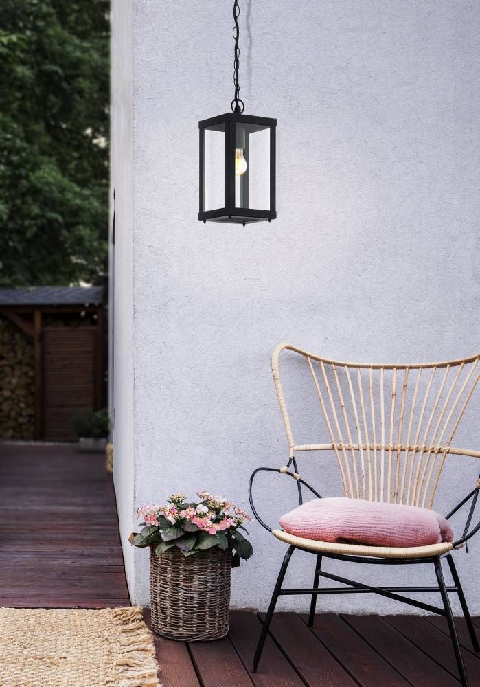 Mise en ambiance sur terrasse avec fauteuil, coussin rose et suspension allumée