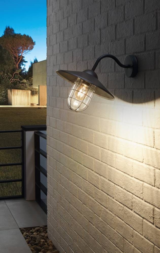 Mise en ambiance nocturne sur mur de briques, halo lumineux chaud, jardin en arrière-plan