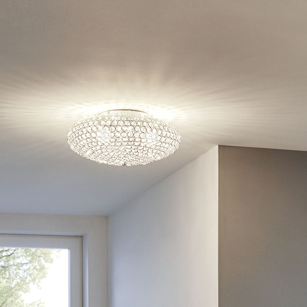 Plafonnier allumé au plafond dans une pièce blanche près d'une fenêtre