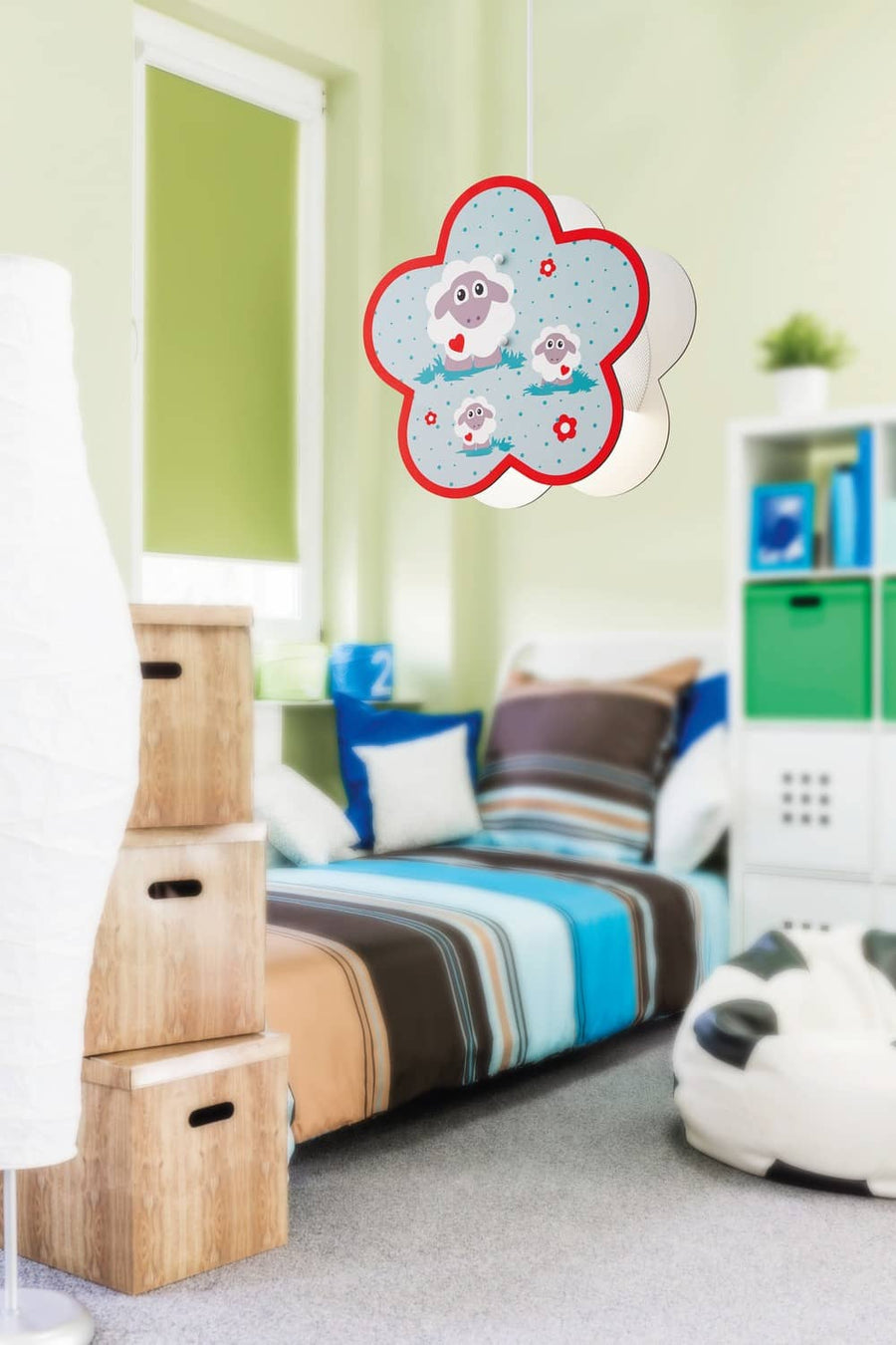 Vue rapprochée du luminaire fleur multicolore suspendu dans une chambre verte avec lit bleu