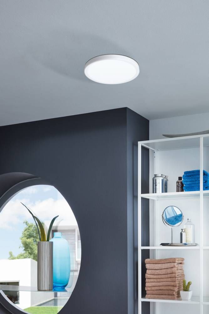Mise en ambiance salle de bain sombre, plafonnier allumé au-dessus du miroir et des serviettes