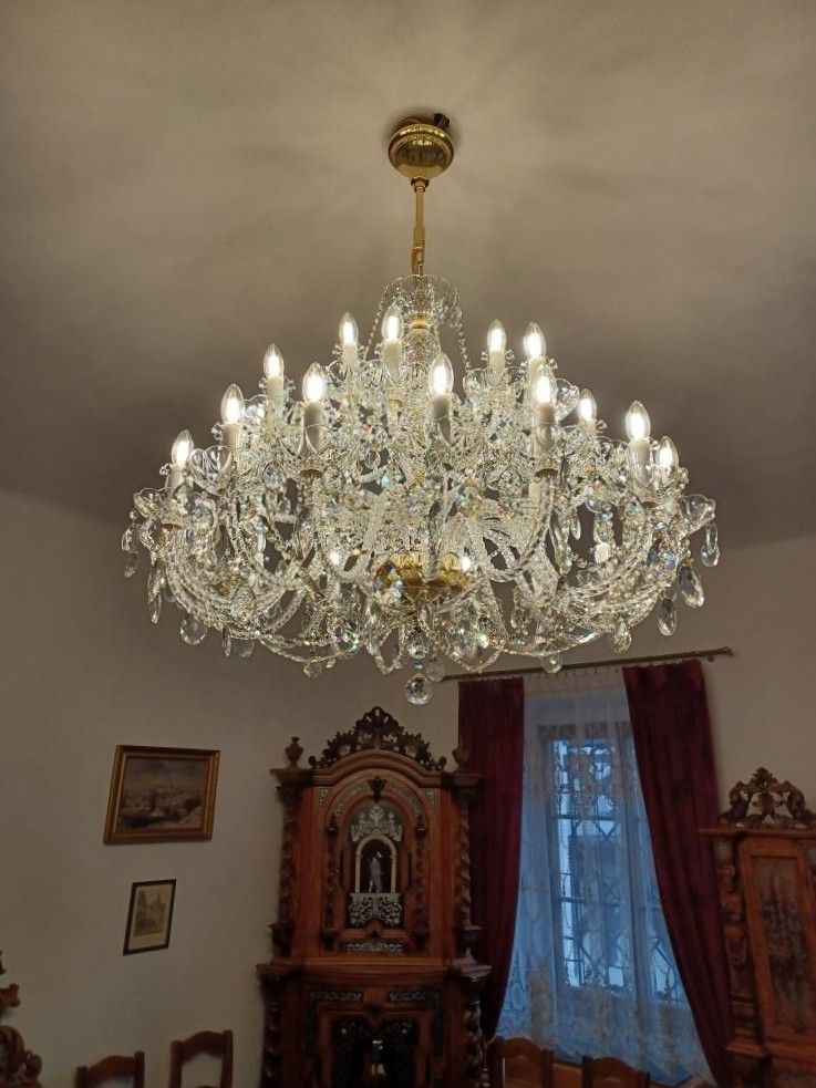 Lustre suspendu au plafond blanc, vu de plus près dans la pièce rustique