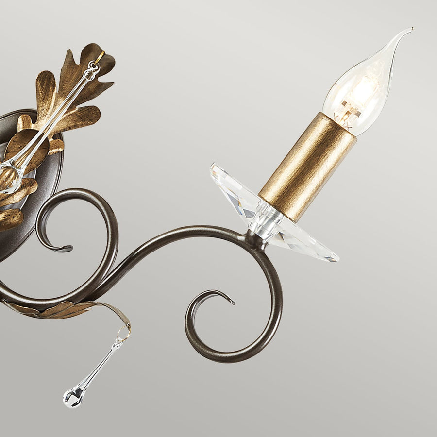 Gros plan d'une lumière avec douille dorée, coupelle cristal et ampoule flamme.