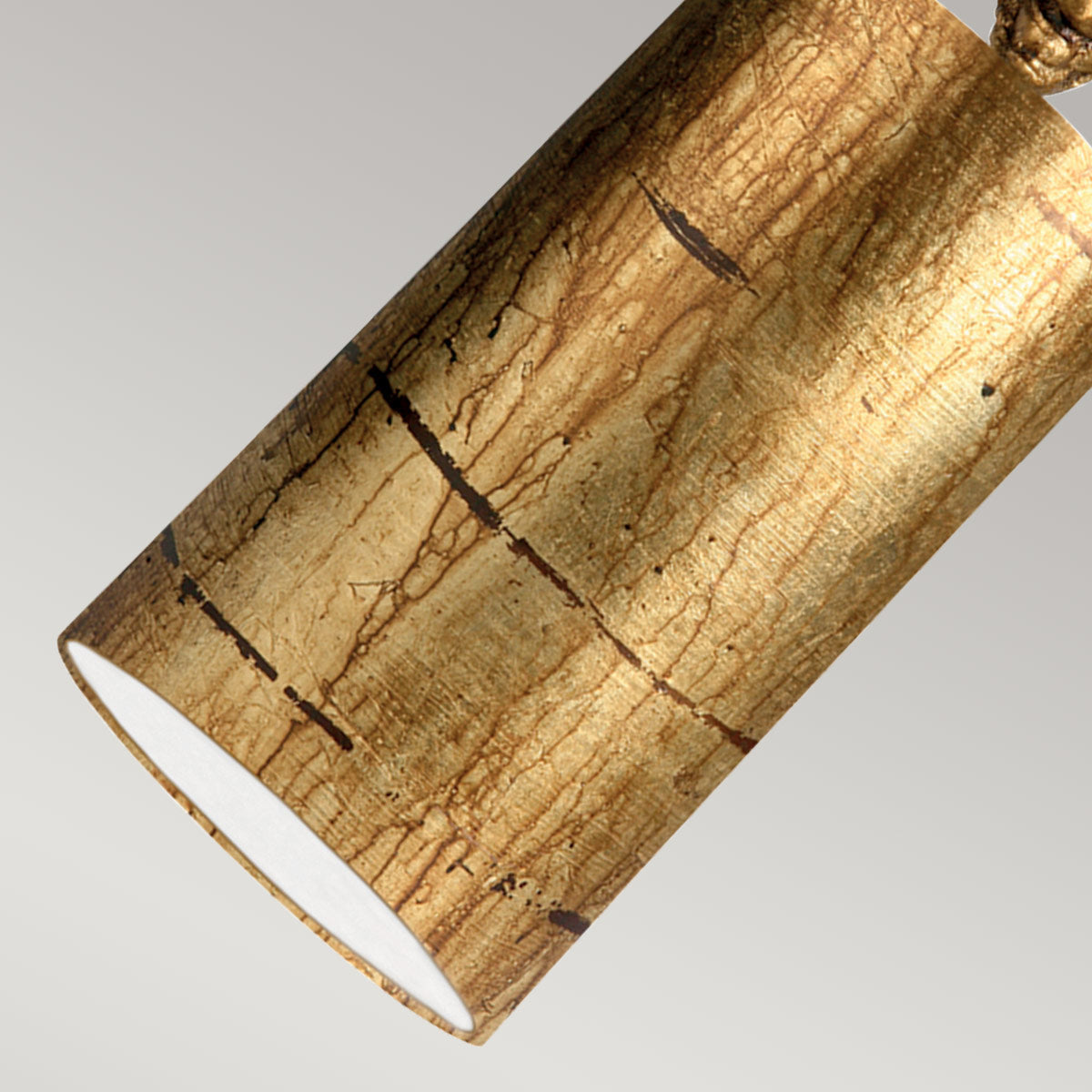Gros plan sur la surface en feuille d'or froissée et l'intérieur blanc du cylindre.