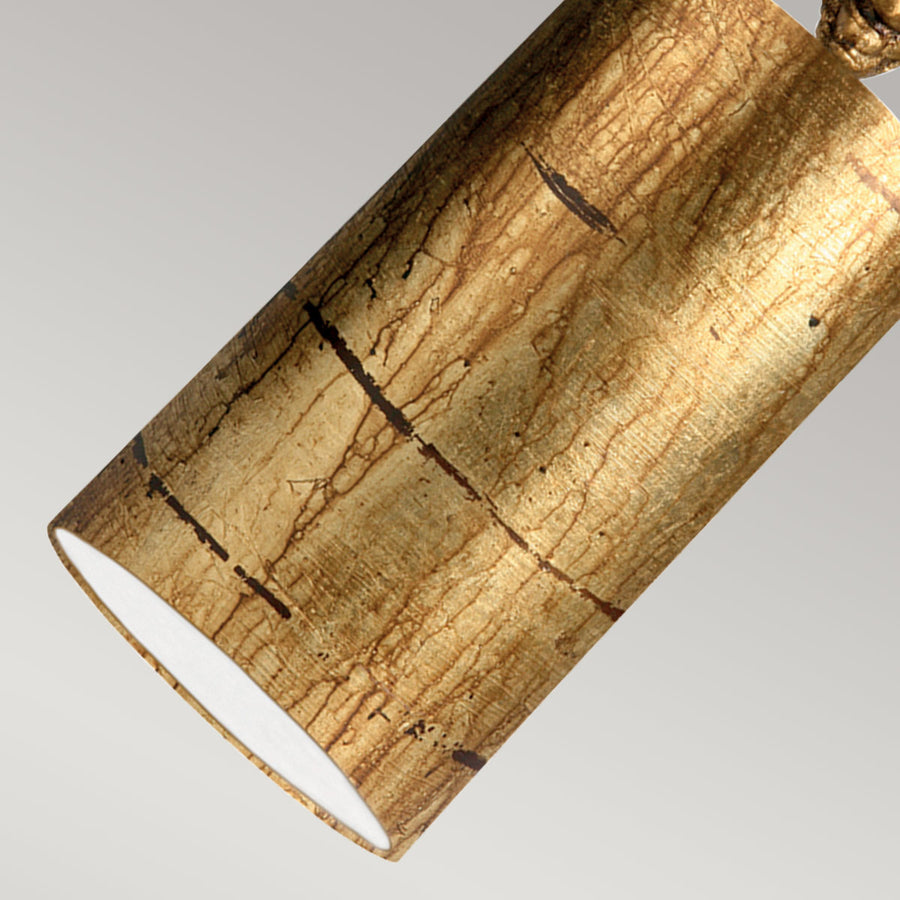 Gros plan sur la surface en feuille d'or froissée et l'intérieur blanc du cylindre.