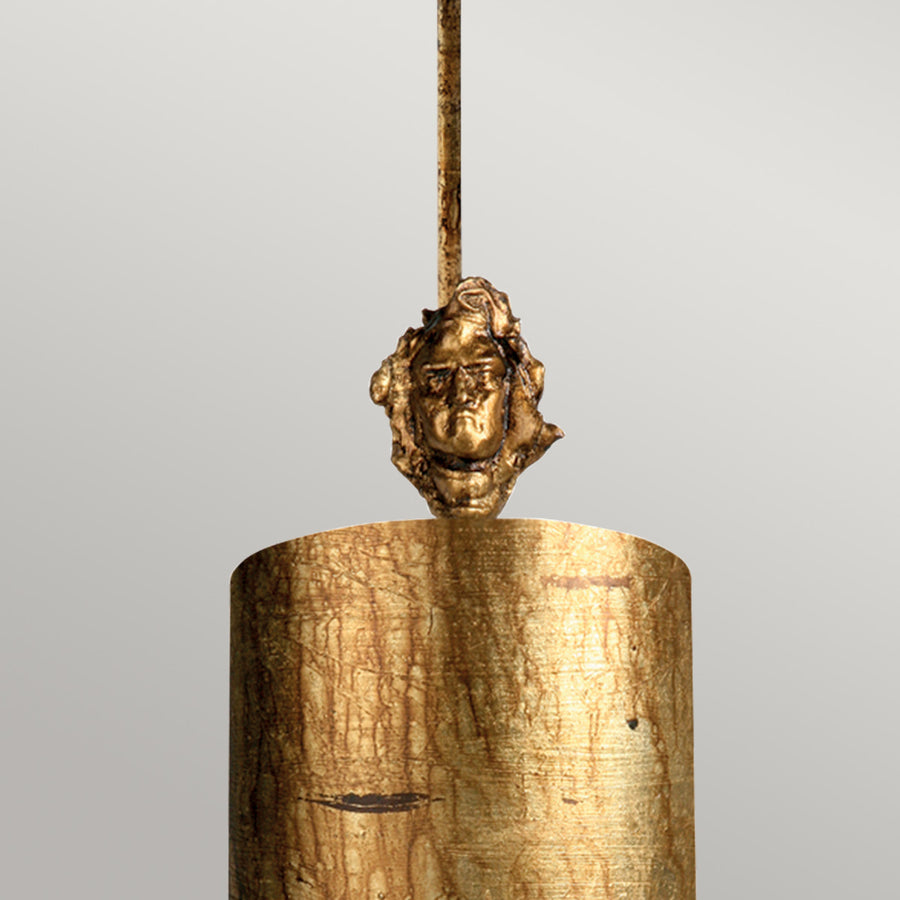 Détail du visage sculpté doré qui orne le sommet de la suspension.