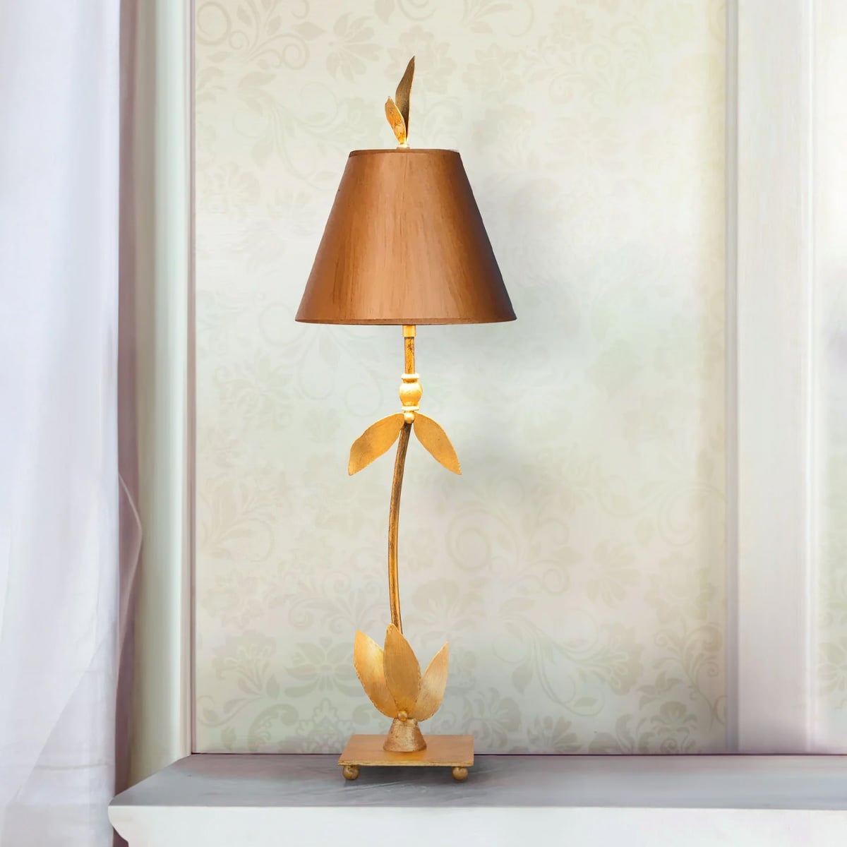 Mise en ambiance de la lampe posée sur une console, papier peint fleuri et rideau.