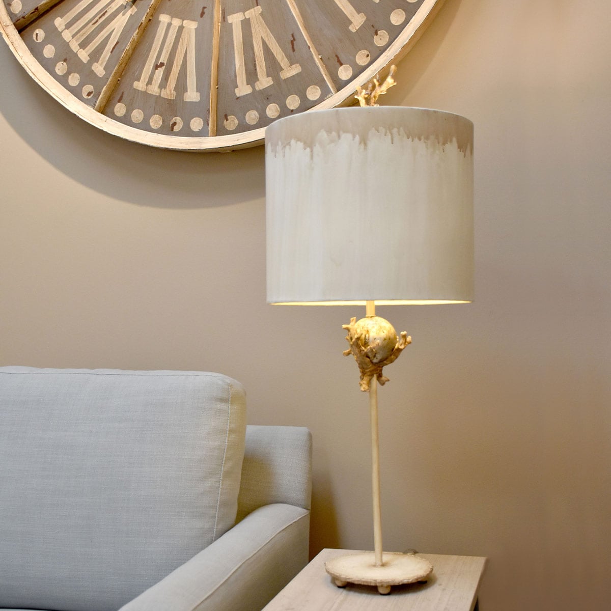 Lampe posée près d'un fauteuil, grande horloge murale et lumière chaude