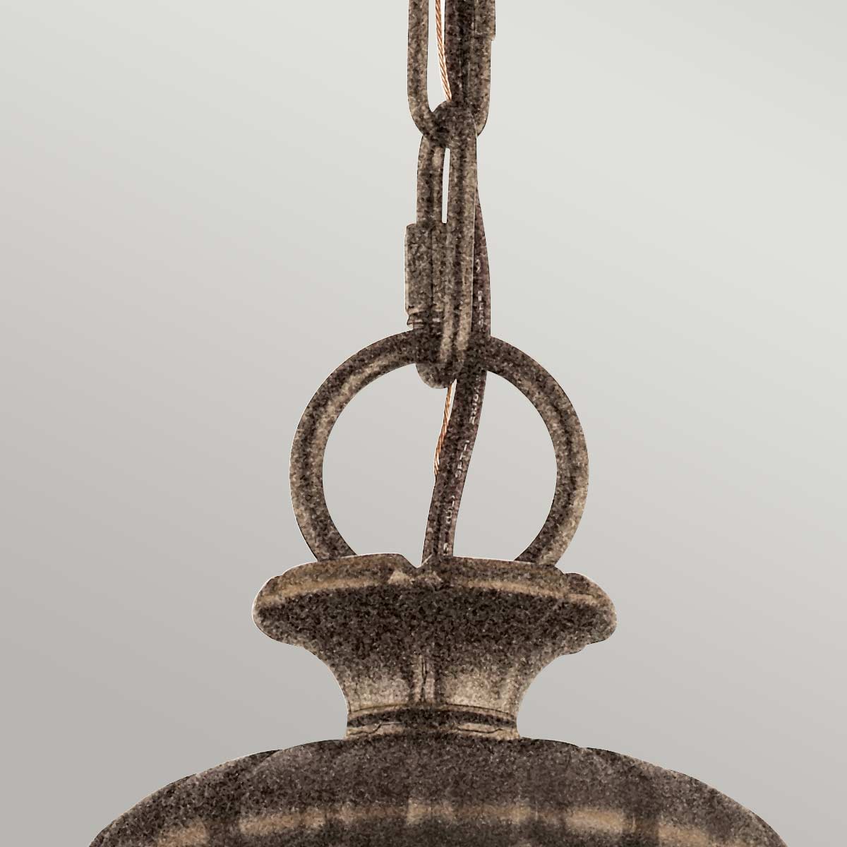 Détail du raccord entre la chaîne et le sommet du luminaire en bronze.