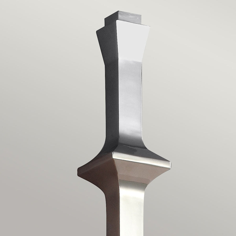 Détail du sommet métallique poli avec formes galbées et reflets brillants.