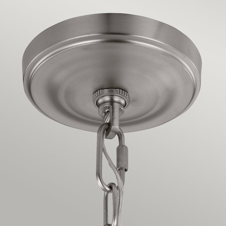 Gros plan sur la rosace de plafond et le maillon de chaîne en métal brossé.