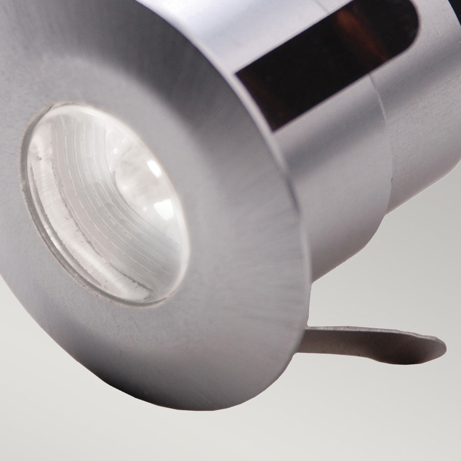 Gros plan sur la lentille transparente et la collerette en aluminium brossé