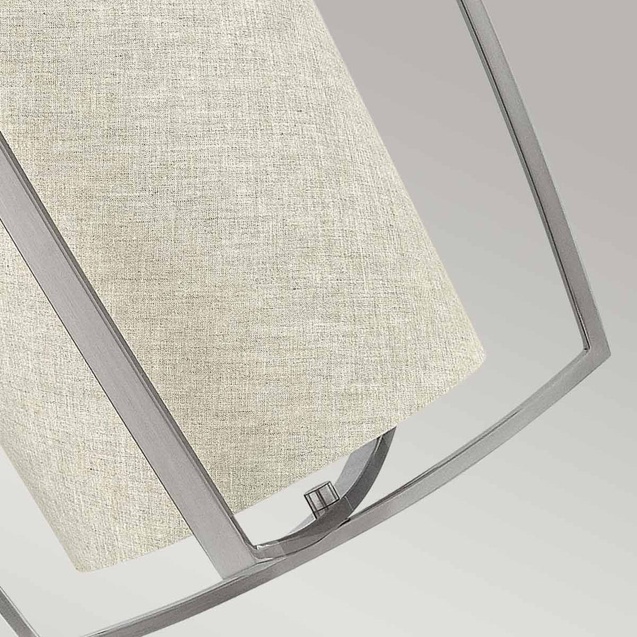 Vue rapprochée de la texture tissée de l'abat-jour et de la structure métallique brossée.