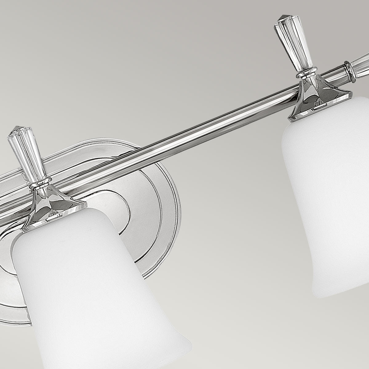 Vue rapprochée de la barre horizontale chromée et des trois supports de verre.