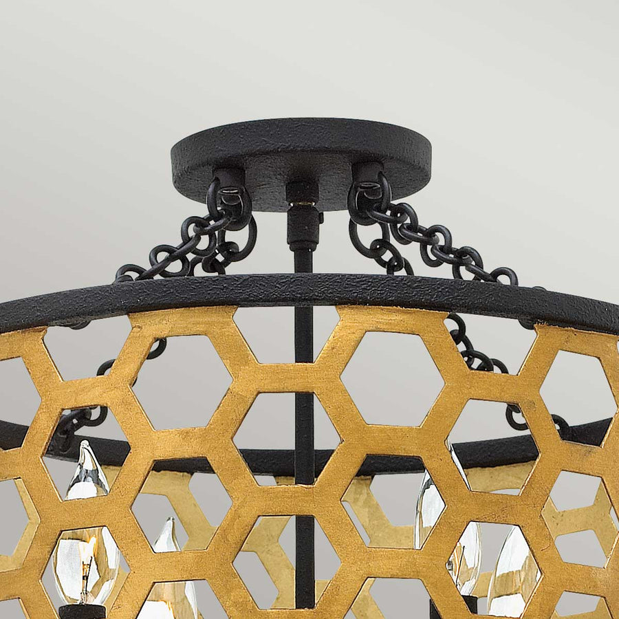 Détail du pavillon de plafond noir et des chaînes supportant l'abat-jour