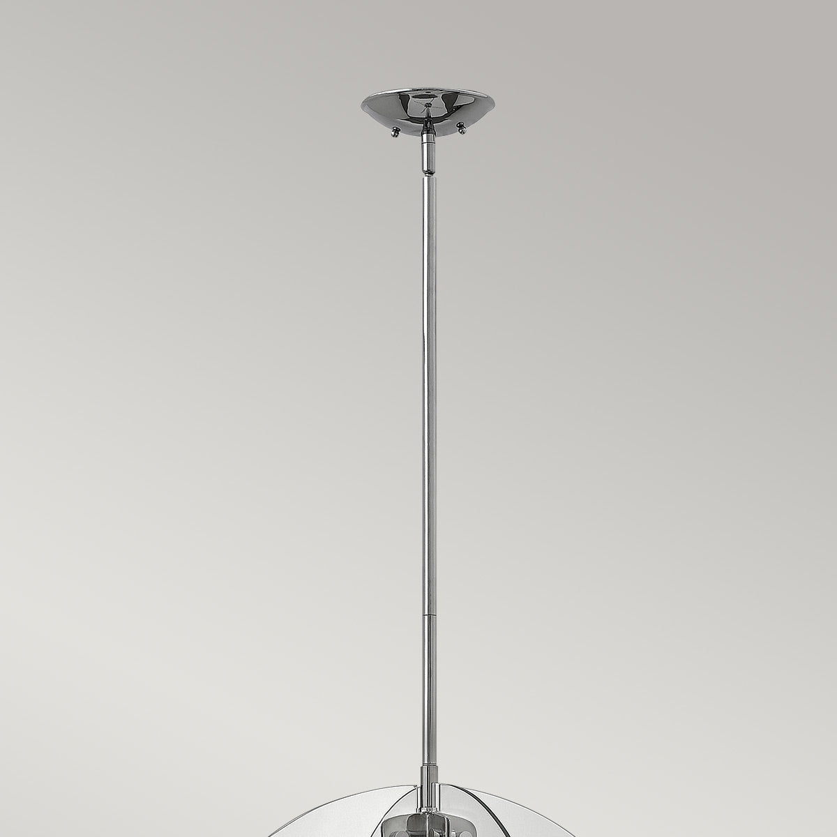 Détail de la rosace au plafond et de la tige chromée verticale.