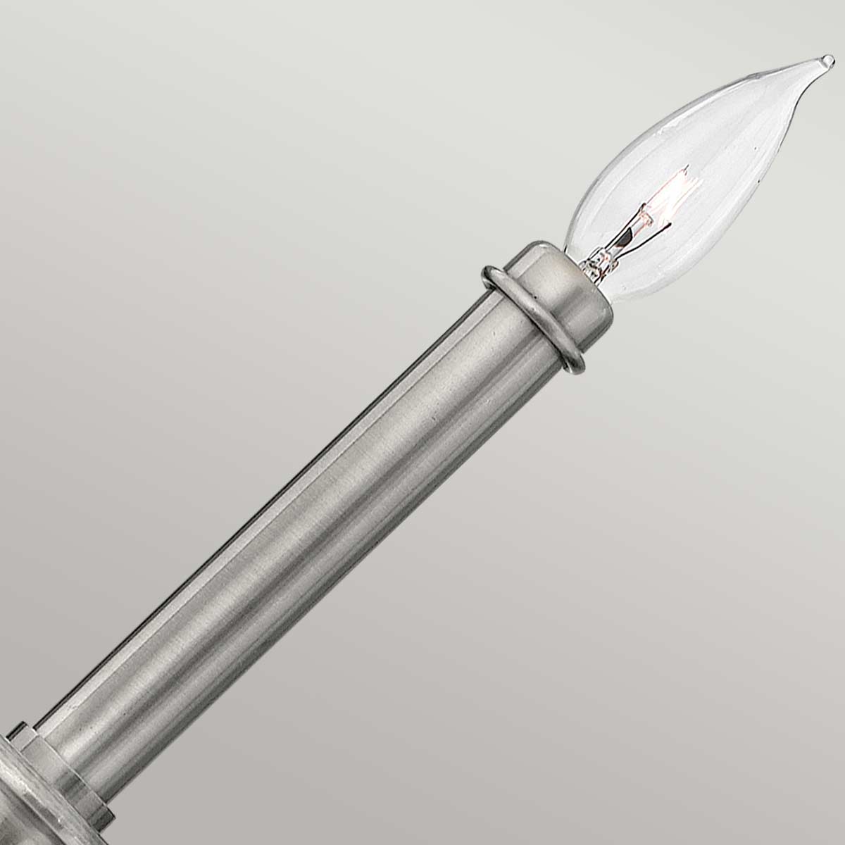 Détail de l'ampoule candélabre transparente vissée sur la douille en nickel