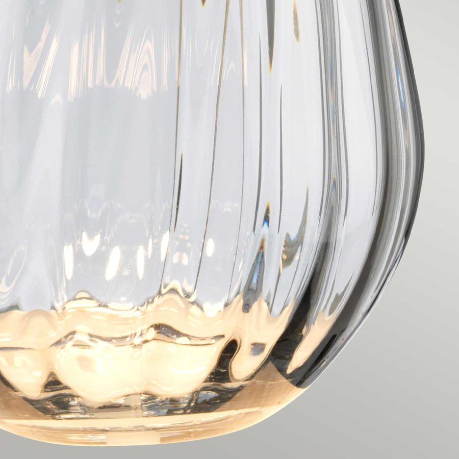 Gros plan sur le verre fumé strié et son fond aux reflets dorés