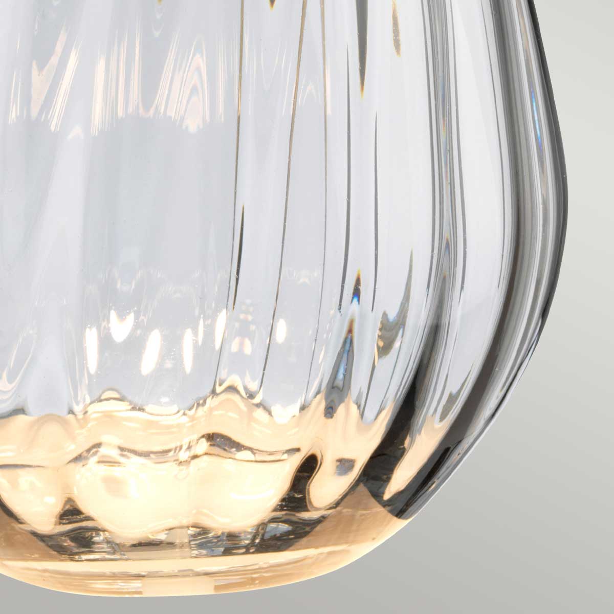 Gros plan sur le verre fumé strié et son fond aux reflets dorés