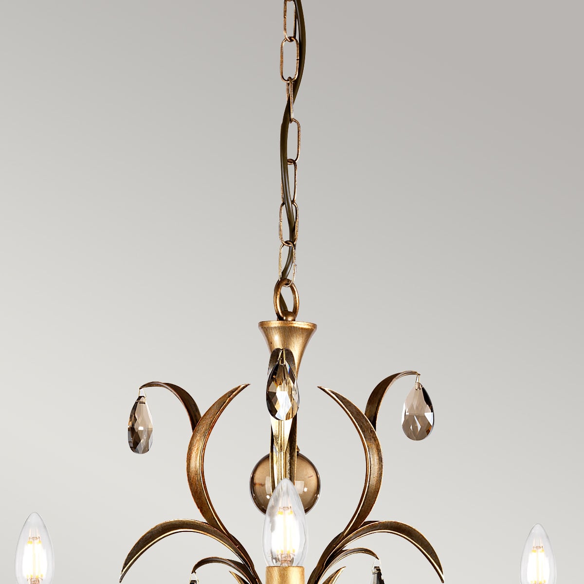 Détail du haut du lustre : chaîne, coupelle et première rangée de pampilles en verre.