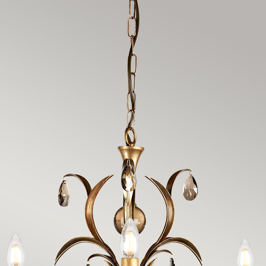 Détail du haut du lustre : chaîne, coupelle et première rangée de pampilles en verre.