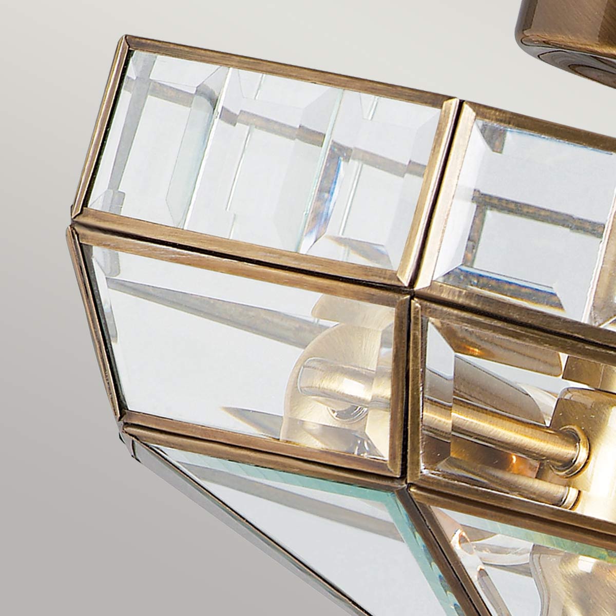 Vue rapprochée des panneaux de verre biseautés et de la structure en laiton.