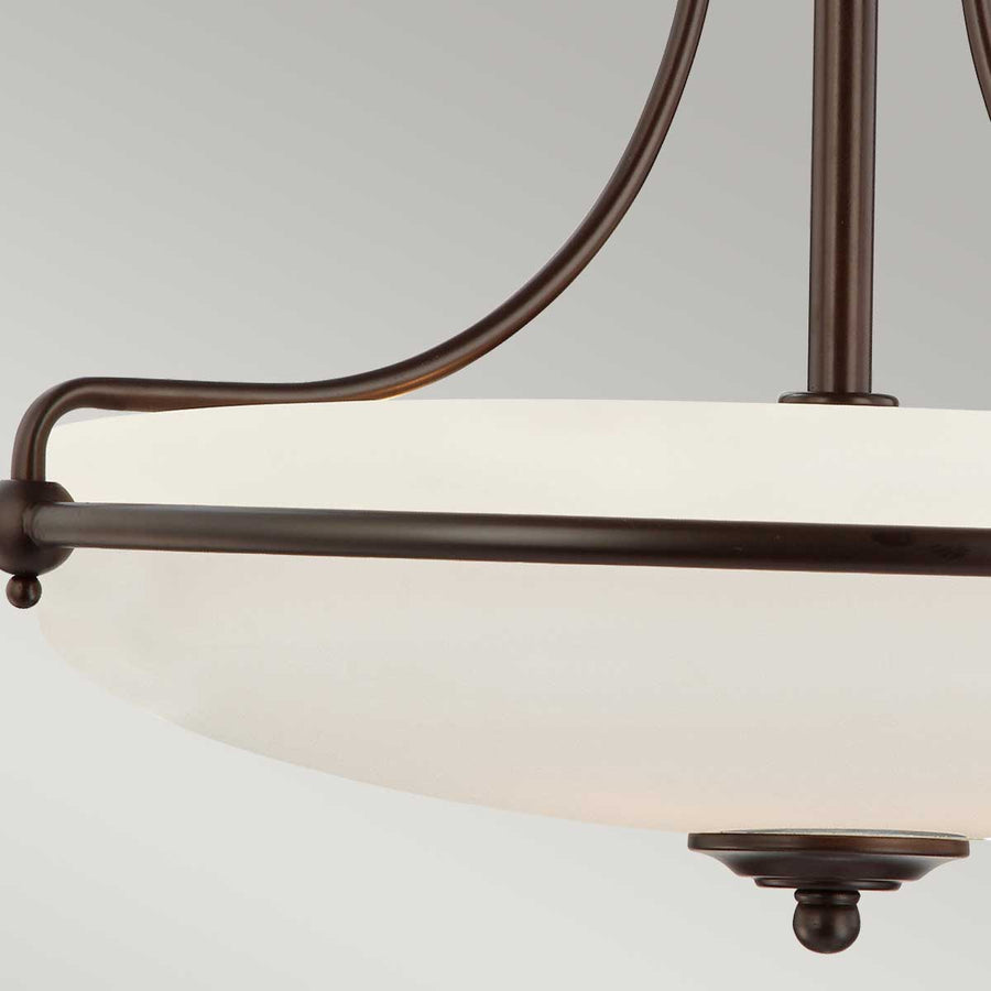 Vue rapprochée des bras courbes et du cabochon en bronze patiné