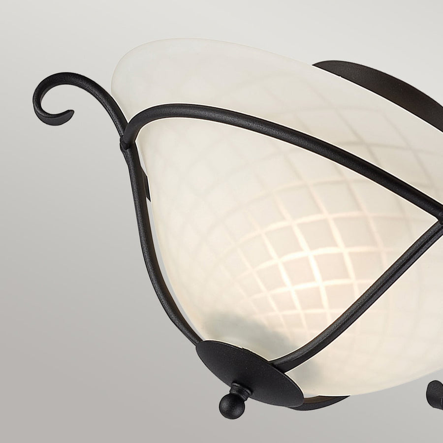 Détail de l'enroulement décoratif en fer forgé et du cabochon inférieur