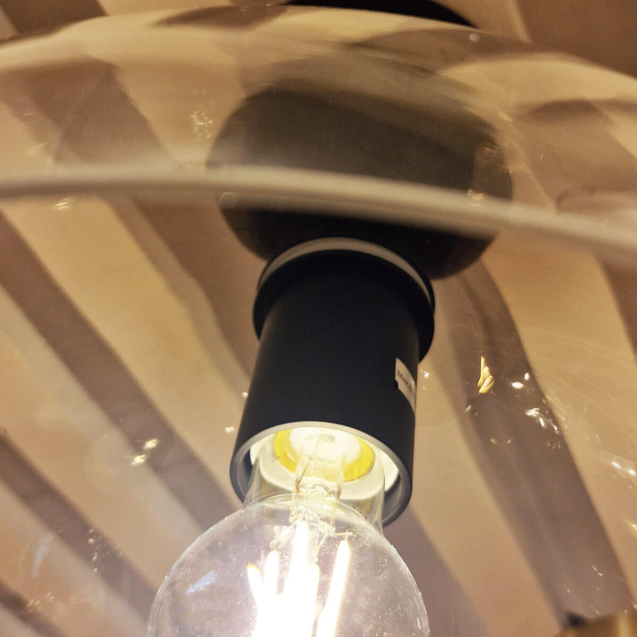 Détail de la douille noire et de l'ampoule transparente à l'intérieur du globe en verre