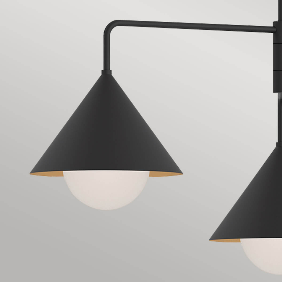 Gros plan sur un abat-jour conique noir, intérieur doré et diffuseur en verre opalin.