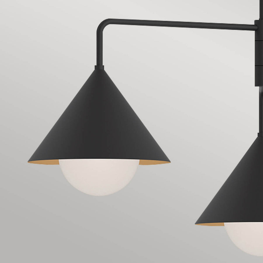 Gros plan sur un abat-jour conique noir, intérieur doré et diffuseur en verre opalin.