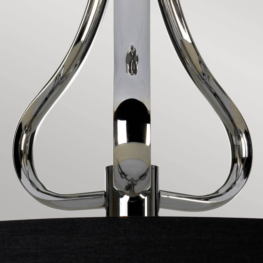 Gros plan sur la courbe chromée en goutte reliant le bras central
