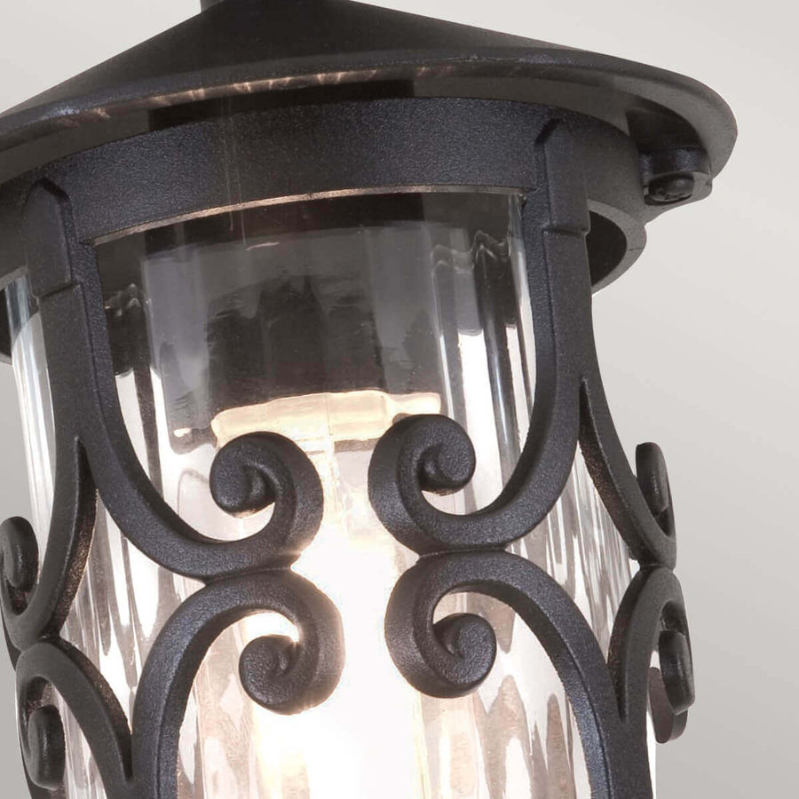 Gros plan sur les volutes métalliques noires devant le verre cannelé