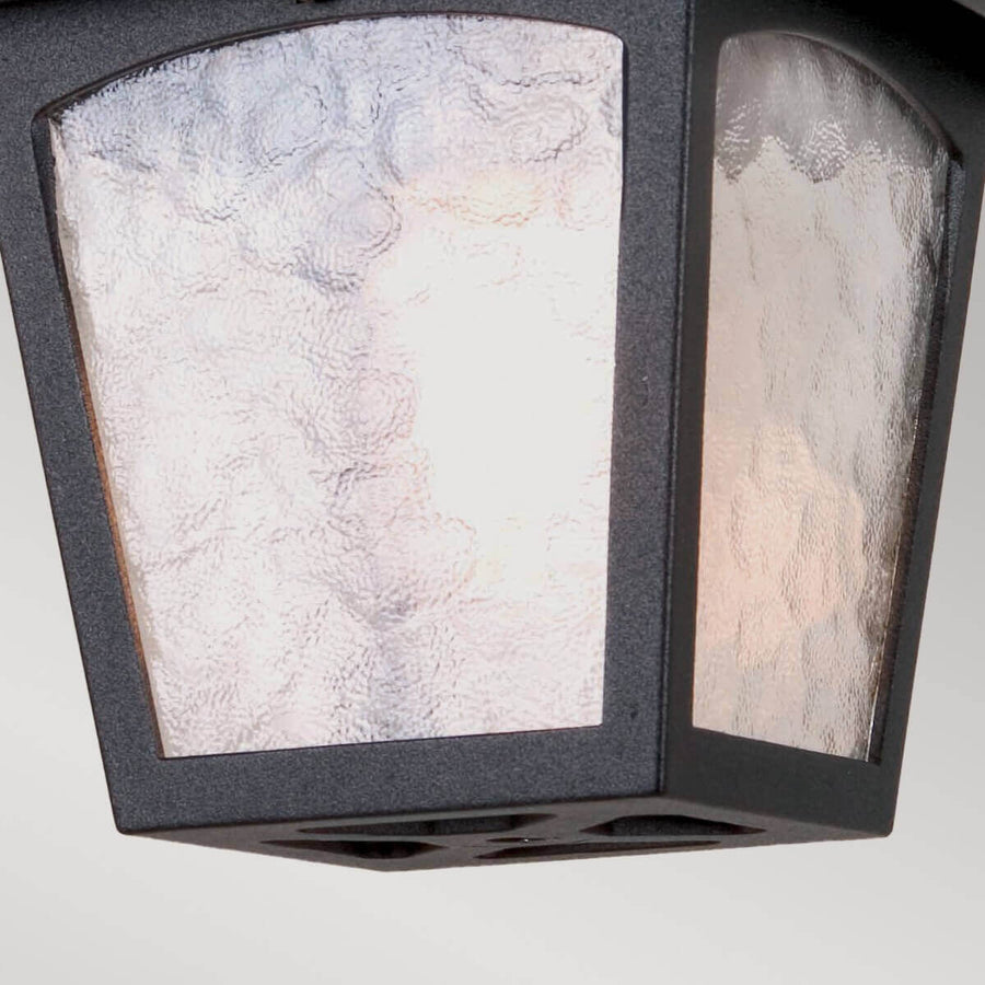 Gros plan du verre texturé et de la base ajourée du luminaire