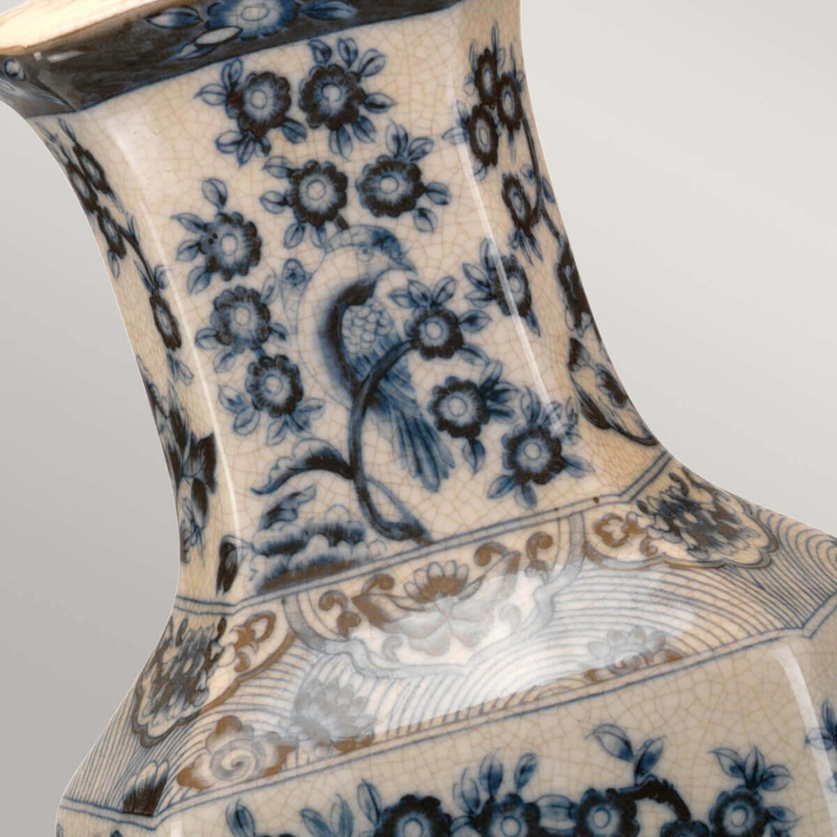 Détail du col en porcelaine avec oiseau bleu et glaçure craquelée beige.