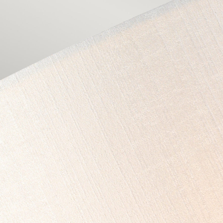 Gros plan de la texture du tissu crème, fines rainures verticales légèrement satinées.