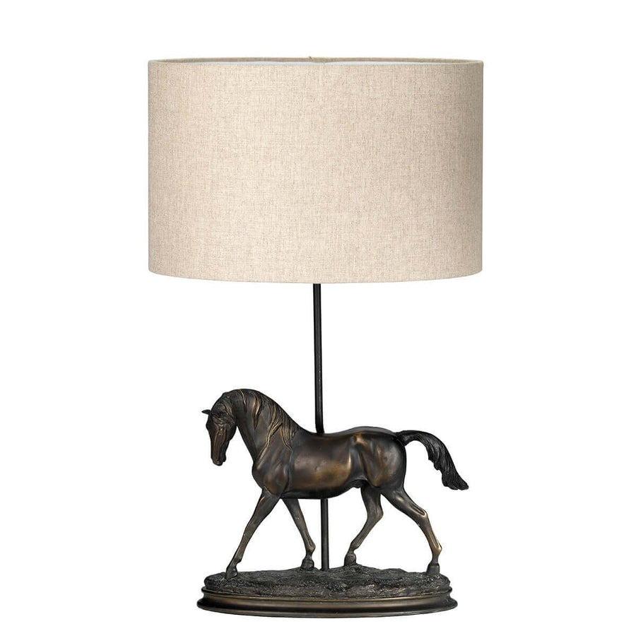 Vue de face du luminaire : abat-jour cylindrique et cheval sculpté sur socle