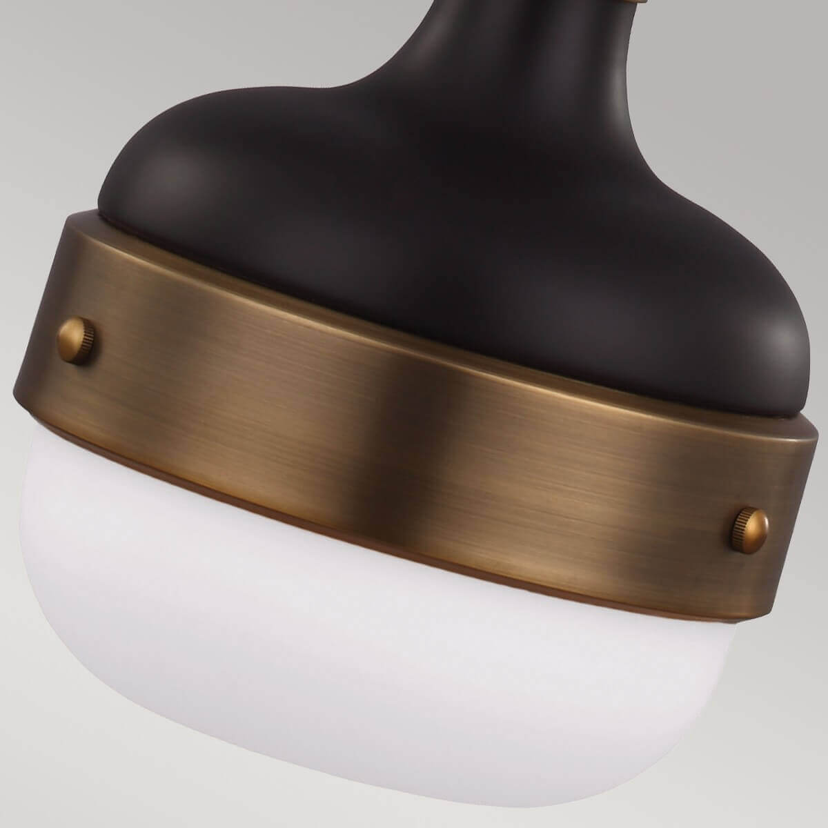 Détail du bas du luminaire avec bandeau en laiton vissé et verre blanc.