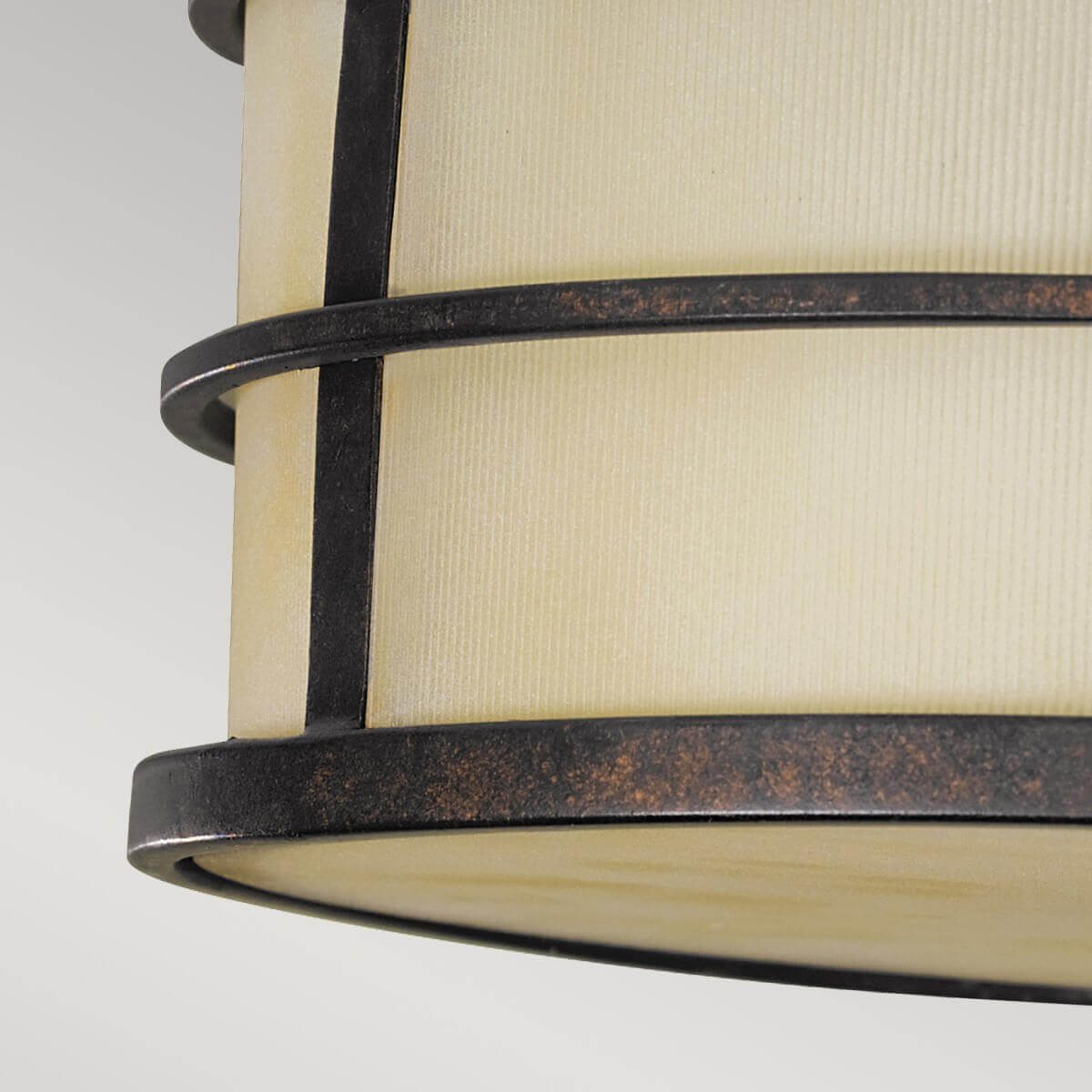 Gros plan sur le cerclage métallique et le diffuseur strié couleur ivoire du luminaire