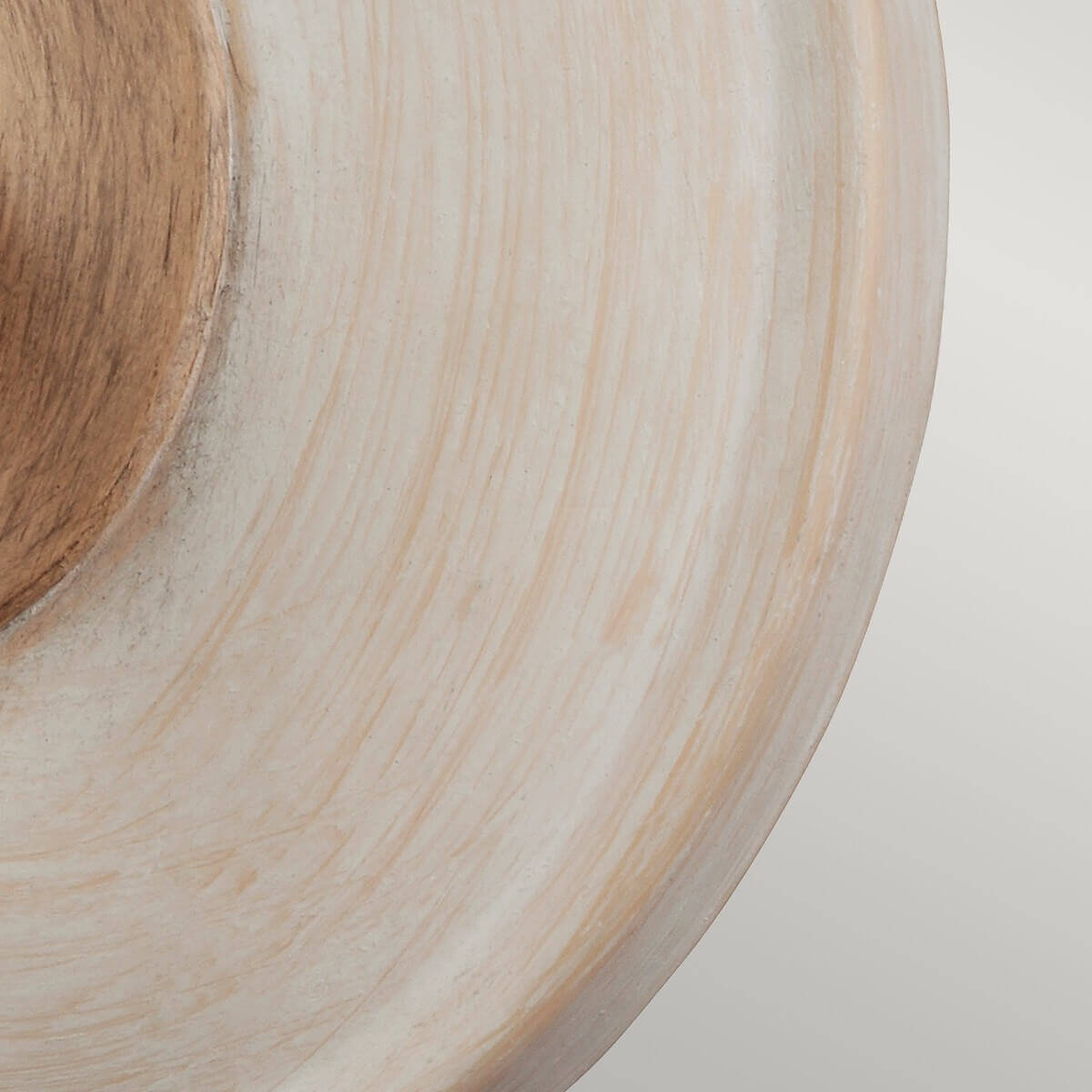 Zoom sur la platine ronde en bois peint blanc aux veines apparentes
