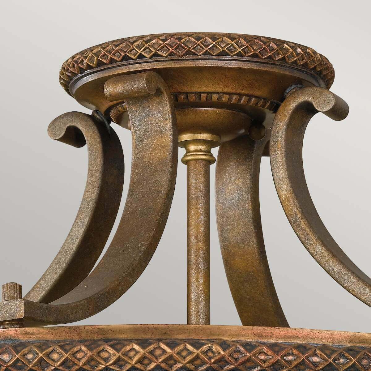 Détail de la monture métallique dorée et de la rosace à frise tressée