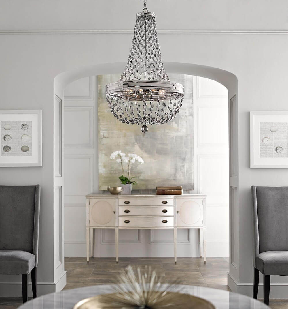 Lustre suspendu sous une arche, mise en ambiance dans une entrée grise avec console claire