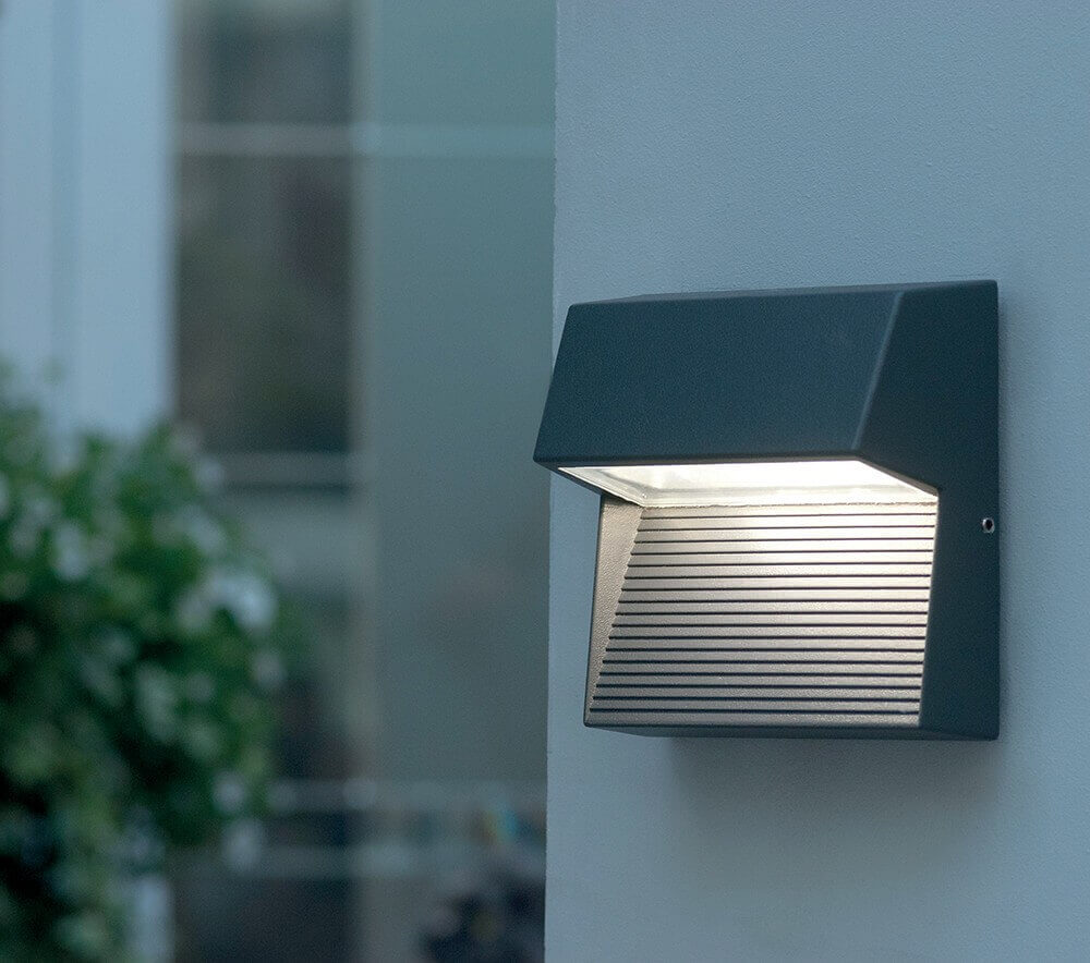 Vue en situation sur un mur gris, lumière allumée dans un jardin