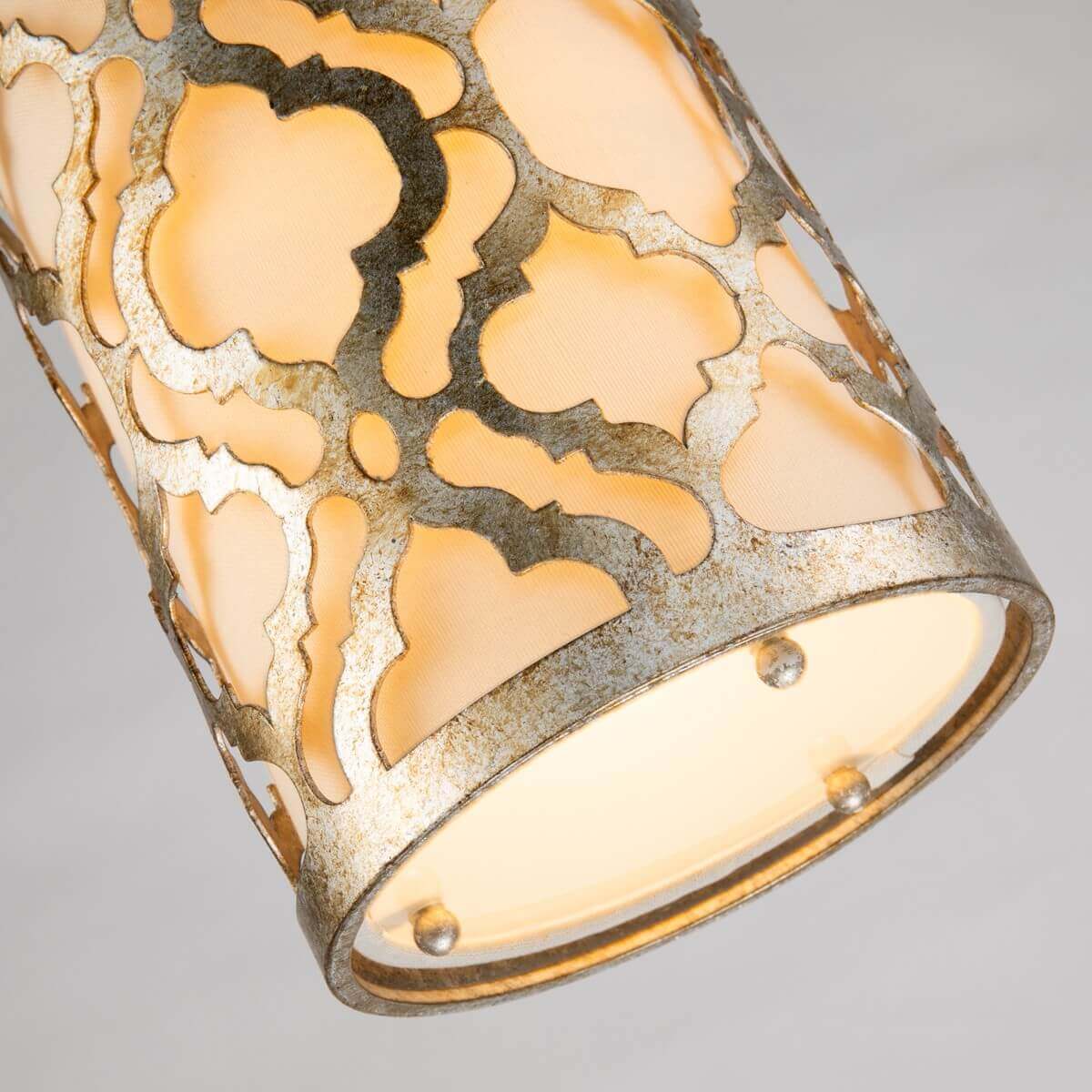 Détail du bas de l’abat-jour cylindrique avec finition dorée et motif ajouré