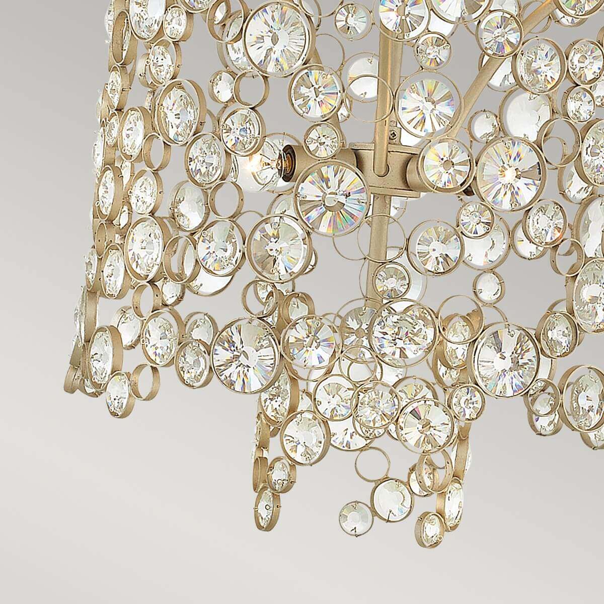 Vue rapprochée du bas du luminaire avec cristaux suspendus et ampoules.