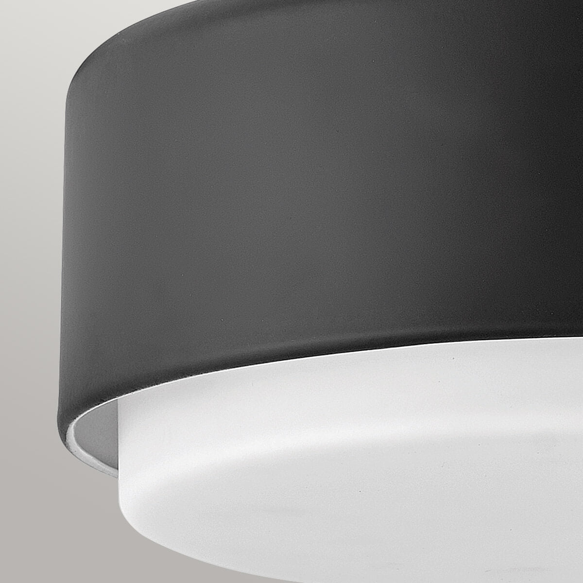 Détail du bord inférieur du cylindre noir surmontant le diffuseur blanc lumineux