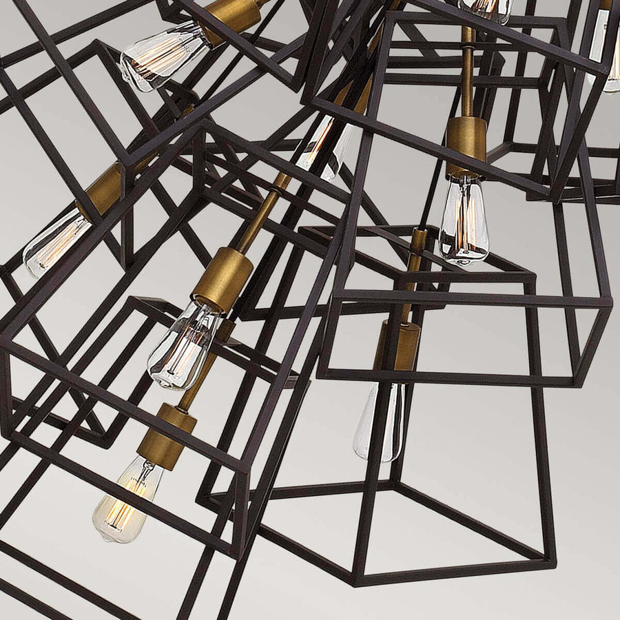 Gros plan sur les cages métalliques noires et les douilles bronze soutenant les ampoules Edison transparentes.