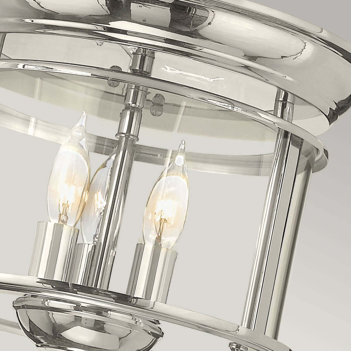 Gros plan sur les trois ampoules à filament allumées dans la cage en verre