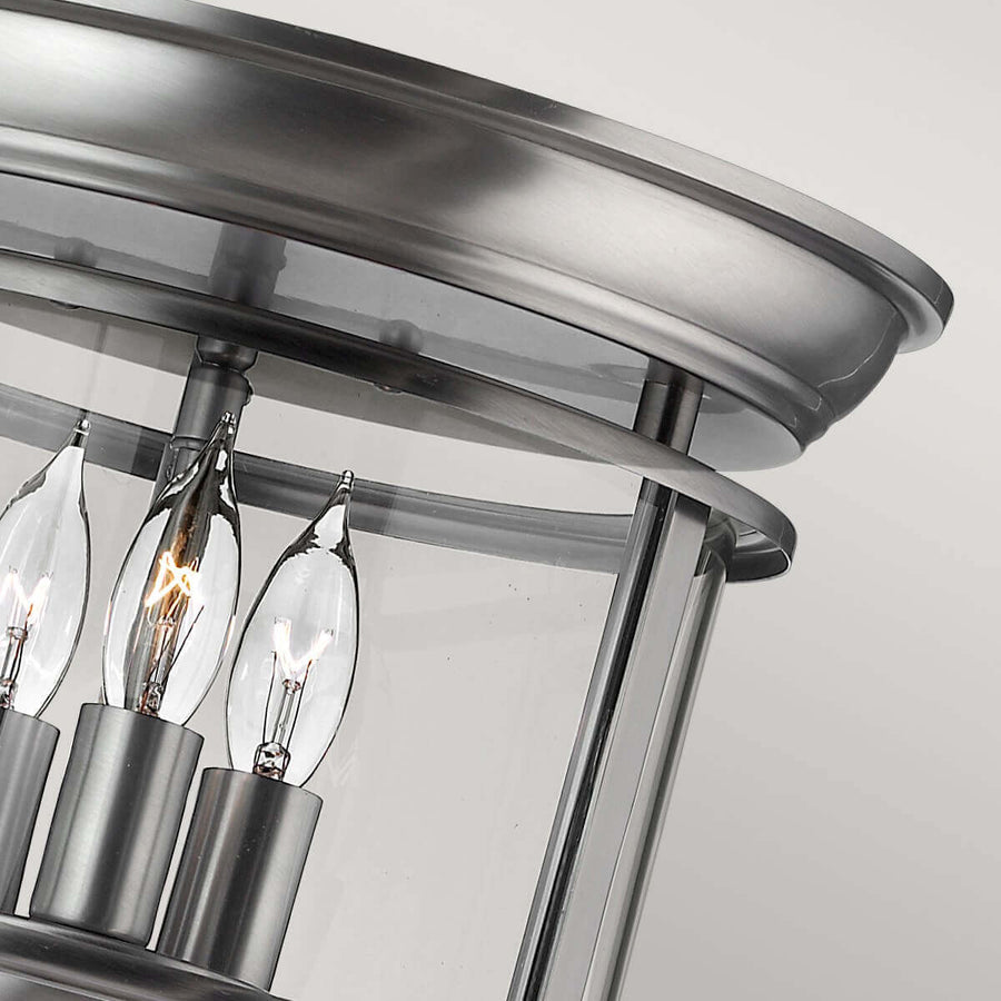 Détail du cercle métallique brossé et des douilles maintenant les ampoules.